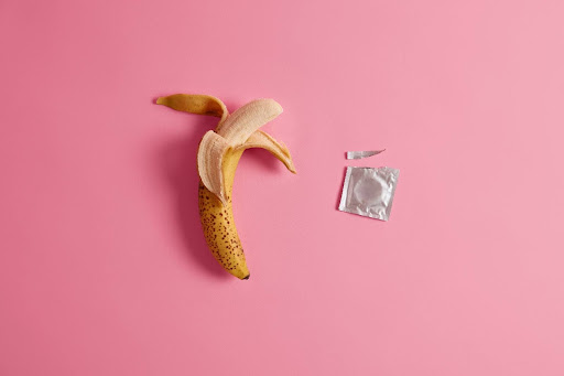 An image showing a peeled banana and open condom packet